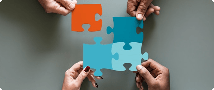 Hands assembling colorful puzzle pieces together