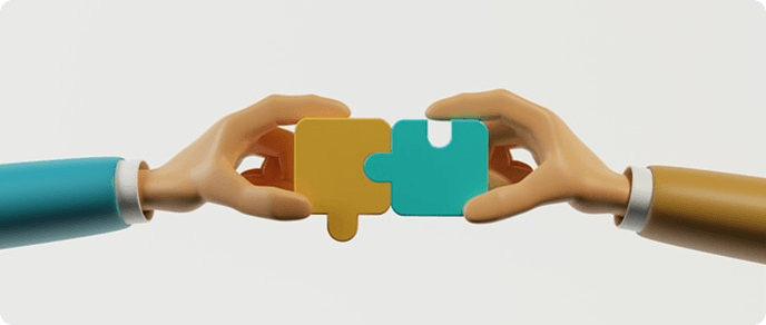 Two hands connecting yellow and teal puzzle pieces