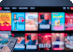 Hand holding a remote while browsing streaming subscriptions on a television