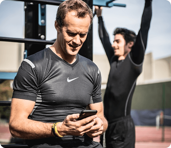 Personal trainer using a fitness app at an outdoor gym
