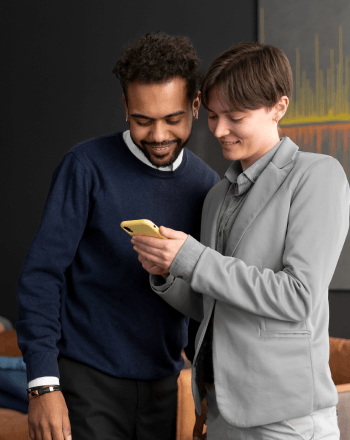 Business colleagues reviewing a logistics app on a smartphone together