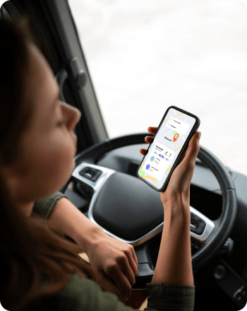 Delivery driver using a logistics navigation app inside a truck cabin