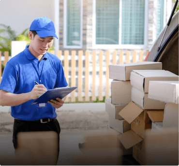 Delivery worker with clipboard next to packages