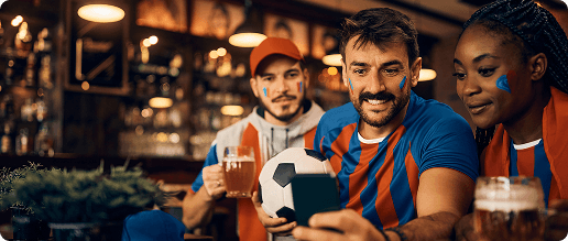 Sports fans celebrating together while looking at a smartphone