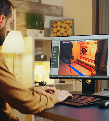 Designer working at a workstation with a detailed interface on screen