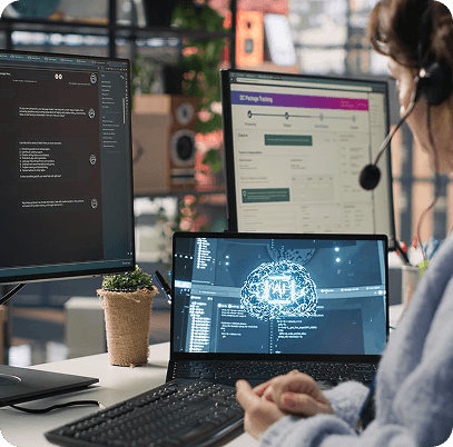 Professional working at a multi-monitor workstation with AI and tracking dashboards