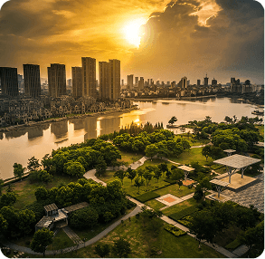 Aerial view of a city skyline and park along a river at sunset
