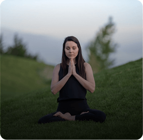 Woman meditating outdoors in a peaceful setting