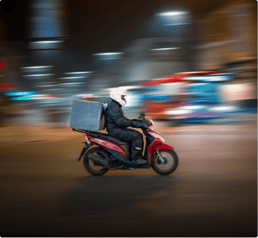 Food delivery rider on a scooter at night