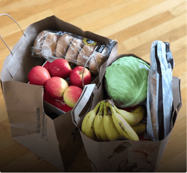 Paper grocery bags filled with fresh produce