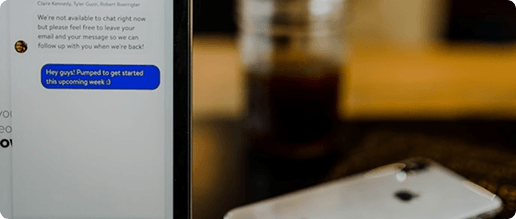 Chat interface with a message bubble beside a phone on a desk