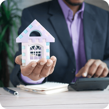 Professional holding a model house in an office setting