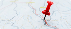 Red location pin placed on a printed map
