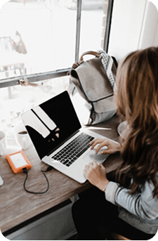 Travel consultant working on a laptop beside a bright window