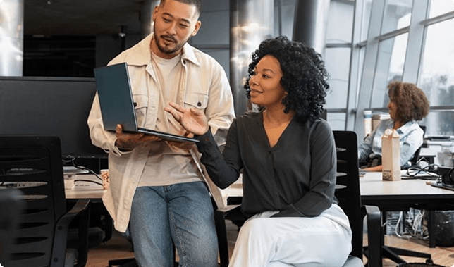 Business leaders reviewing strategy on a laptop in a modern office