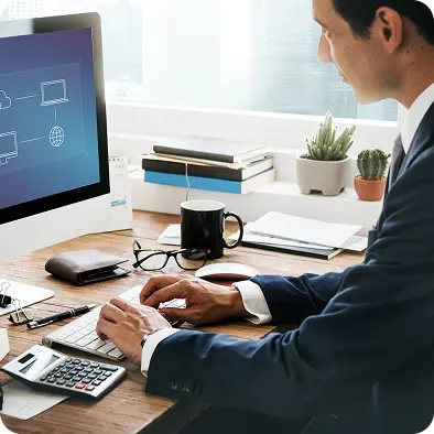 Professional working at a desk with a network diagram on the monitor