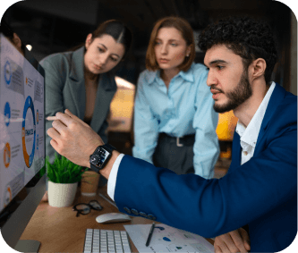 Diverse team reviewing a chart on a desktop monitor