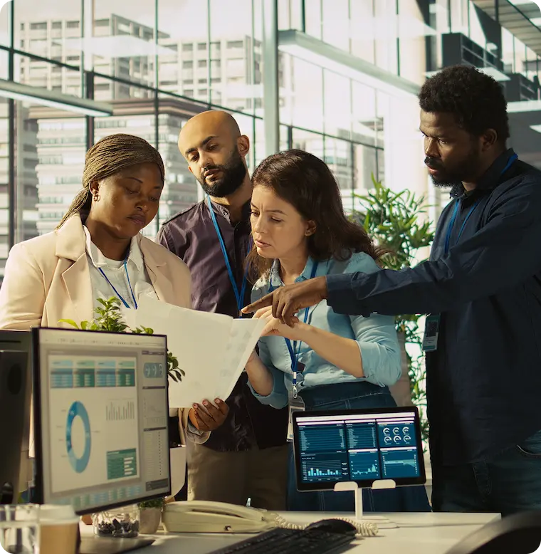 IT team reviewing infrastructure reports around office screens